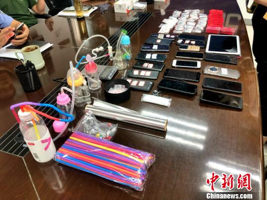 圖為警方繳獲的吸毒工具、作案手機(jī)及毒品等?！∠默?攝