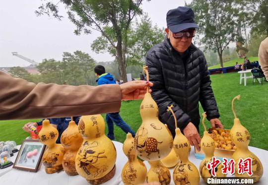 在10月19日開幕的“第二屆金海湖紅葉觀賞季”老北京市集上，有面塑、風(fēng)箏、烙畫葫蘆、瓦當(dāng)制作、拉洋片、刺繡、鏨刻、剪紙、毛猴、發(fā)繡等民俗技藝展示?！堃魂?攝