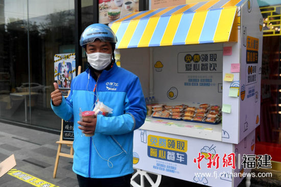 圖為外賣配送員為暖心餐車點贊。 呂明 攝